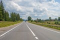 Summer day landscape with forest, cloudy sky and road. Royalty Free Stock Photo