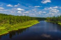 Summer day landscape with river, forest, clouds on the blue sky and sun. Royalty Free Stock Photo