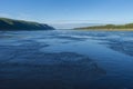 Summer day landscape with river, forest, clouds on the blue sky and sun. Royalty Free Stock Photo