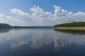 Summer day landscape with river, forest, clouds on the blue sky and sun. Royalty Free Stock Photo