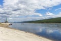 Summer day landscape with river, forest, clouds on the blue sky and sun. Royalty Free Stock Photo