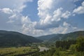 Summer day landscape with road, cloudy sky and small houses. Ukraine, Carpathian. Royalty Free Stock Photo