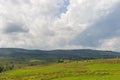 Summer day landscape with road, cloudy sky and small houses. Ukraine, Carpathian. Royalty Free Stock Photo