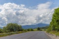 Summer day landscape with road, cloudy sky and small houses. Ukraine, Carpathian. Royalty Free Stock Photo