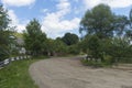 Summer day landscape with road, cloudy sky and small houses. Ukraine, Carpathian. Royalty Free Stock Photo