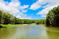 Summer day landscape with wooden pontoon bridge on a forest lake Royalty Free Stock Photo