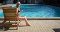 Summer day life women relaxing next to the luxury sunbathing pool on the beach of the outdoor hotel resort. sitting on a Royalty Free Stock Photo