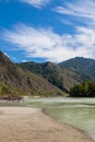 Summer day in mountainous Altai on the banks of the Katun river with turquoise water and mountain ranges covered with green forest