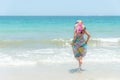 Summer Day. Smiling woman wearing fashion summer walking on the sandy ocean beach. Royalty Free Stock Photo