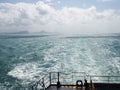 Summer day travelling by ferry boat ship. boat propeller wake foam water sea surface in wash blue Royalty Free Stock Photo