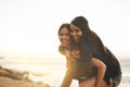Summer days were made to play. two young women enjoying a piggyback ride at the beach. Royalty Free Stock Photo