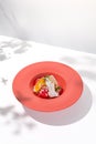 Summer dessert - berry sorbet with citrus and crispy waffles. Strawberry gelato on red ceramic plate. Frozen dessert from