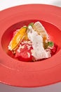 Summer dessert - berry sorbet with citrus and crispy waffles. Strawberry gelato on red ceramic plate. Frozen dessert from