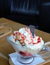 Summer dessert. Hot strawberries and vanilla ice cream with whipped cream on a glass bowl. Royalty Free Stock Photo