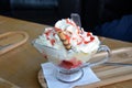 Summer dessert. Hot strawberries and vanilla ice cream with whipped cream on a glass bowl. Royalty Free Stock Photo