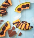 Summer dessert Slices of melon with dark chocolate on skewers. Healthy dessert