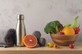 Summer diet and fitness concept. Bottle of water, towel, dumbbells, vegetables and fruits on wooden table