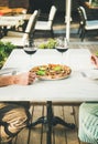 People enjoying fresh pizza and red wine in outdoor cafe Royalty Free Stock Photo