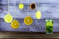 Summer drink. Hanging on threads slices of lemon, orange and lime. Summer fresh Mojito with ice. Royalty Free Stock Photo