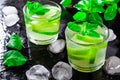 Summer drink Mojito, with lime, mint and ice cubes, on a black background with water drops Royalty Free Stock Photo