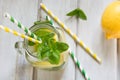 Summer drink, water detox with lemon, ice and mint in mason jar on a white wooden background. Royalty Free Stock Photo