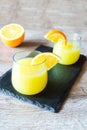 Summer drinks, orange juice coctails in glasses, fresh sliced fruits on cutting desk with copy space Royalty Free Stock Photo