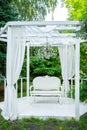 Summer elegant elegant gazebo in the lush gardens. Exquisite classic sofa gazebo Royalty Free Stock Photo