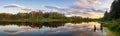 Panorama of the summer evening landscape on the Ural lake with pine trees on the shore, Russia, August Royalty Free Stock Photo