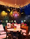 Summer Evening Lighting illumination Street Cafe decoration Table with flowers on top And Lamp Restaurant outdoor in the city rela Royalty Free Stock Photo