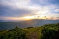 Summer evening mountain landscape with grassy hills and distant peaks at colorful sunset Royalty Free Stock Photo