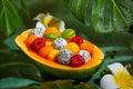 Summer exotic fruit salad in half of papaya. Healthy sweet dessert with mango, papaya, pitaya, passion fruit and raspberry Royalty Free Stock Photo