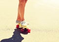 Legs of young woman riding skateboard on road Royalty Free Stock Photo