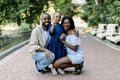 Summer family portrait in nature outdoors. Beautiful young African American family with cute little daughter, posing in