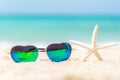 Summer Fashion heat shape sunglasses on sea beach under clear blue sky.