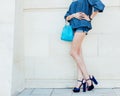 Summer. Fashion. Leggy young woman posing in denim outfit and fashionable handbag Royalty Free Stock Photo