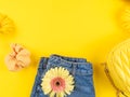 Summer fashion outfit frame background with jeans shorts, shoes, trendy handbag, flowers on yellow