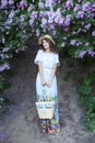 Summer fashion portrait of stunning woman walking in the blooming lilac garden. Wearing long vintage dress. Romantic mood. Secret Royalty Free Stock Photo