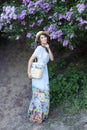 Summer fashion portrait of stunning woman walking in the blooming lilac garden. Wearing long vintage dress. Romantic mood. Secret Royalty Free Stock Photo