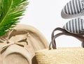 Summer fashion tropical vacation concept. Women`s female beachwear straw hat wicker shoulder bag green palm leaves on white stone Royalty Free Stock Photo