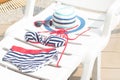 Summer Fashion woman swimsuit bikini stripes,red eyewear sunglasses,hat on bench at edge poolside Royalty Free Stock Photo