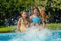 Summer fitness, kids in swimming pool have fun, smiling girls splash in water Royalty Free Stock Photo