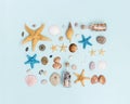 Summer flat lay with colorful sea stars, seashells, pebble stones on blue background. Royalty Free Stock Photo