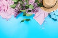 Summer flatlay with pink scarf, straw hat and sungasses on blue