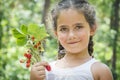 Summer in the forest on a bright sunny afternoon, a little girl, is holding strawberries in her hands. Royalty Free Stock Photo