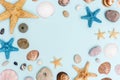 Summer frame from colorful sea stars, seashells, shellfishes, pebble stones on pastel blue with copy space. Royalty Free Stock Photo