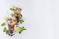 Summer fresh cocktail of cola with ice in two glasses with mint and lime as border on white wood board, top view. Royalty Free Stock Photo