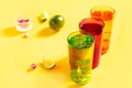 Summer fresh cocktail lemonade water with mint and lime citrus fruit in colorful glasses on yellow background Royalty Free Stock Photo