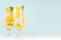 Summer fresh cold cocktails with oranges, green mint, ice, straw on soft light pastel green background and white wood table. Royalty Free Stock Photo