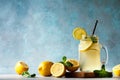 Summer fresh drink with lemons and mint leaves on blue background. Lemonade in jar with straw Royalty Free Stock Photo