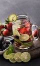 Summer fresh fruit drink. fruit Flavored water mix with strawberries, lime, grape and mint leaves Royalty Free Stock Photo